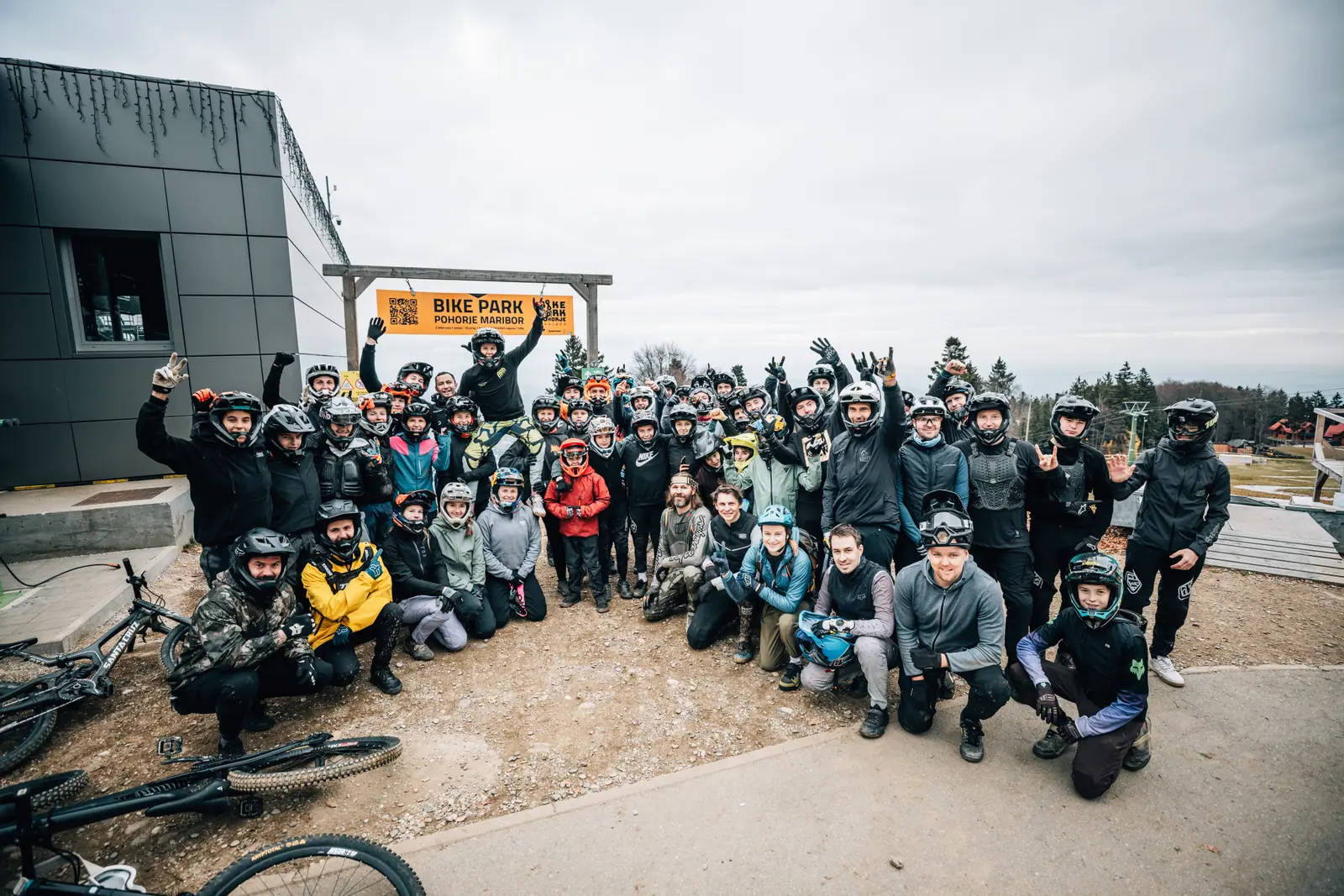 Velika skupina gorskih kolesarjev z zaščitnimi čeladami pred bike parkom